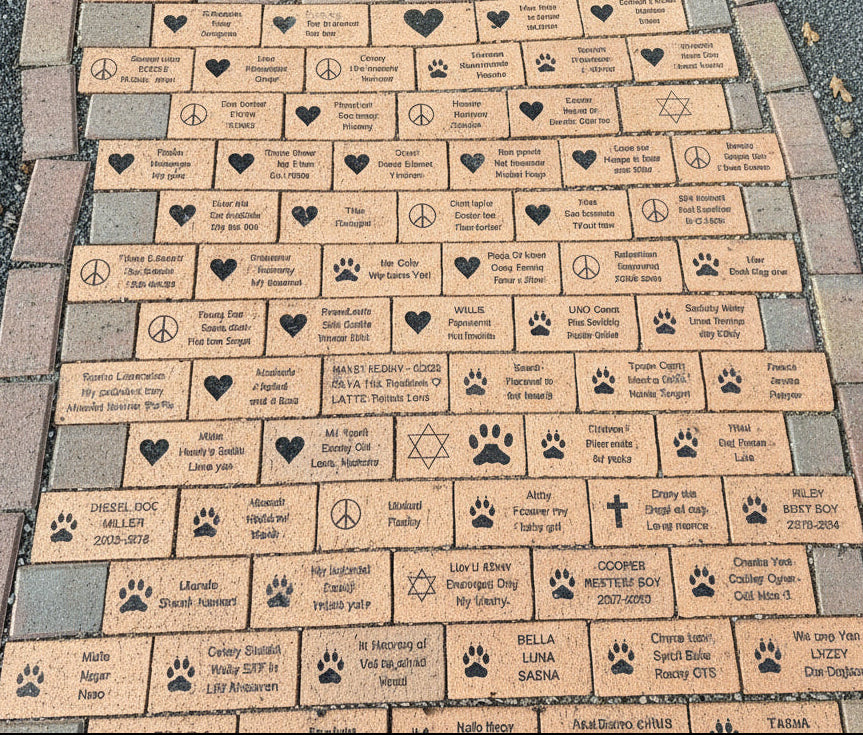 Memorial stone with engraved names and symbols on a pavement